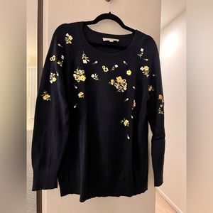 Blue sweater with embroidered yellow flowers.